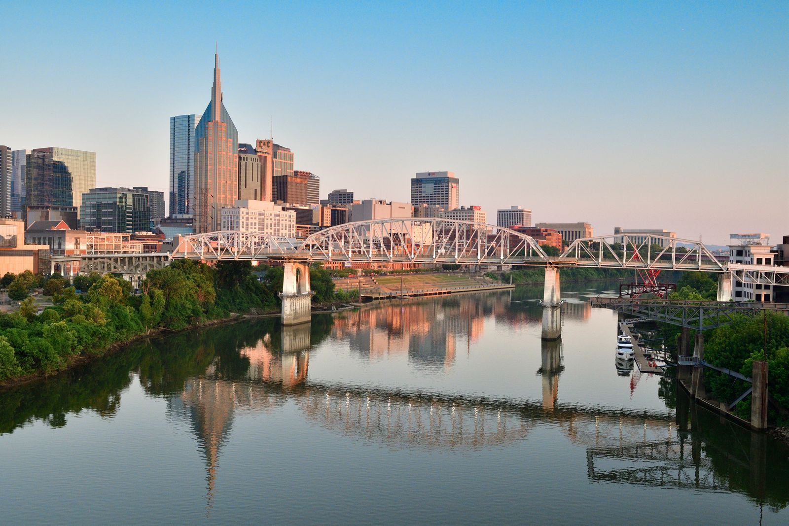 Nashville skyline and a pedestrian bridge reflected in the Cumberland River, the destination of Cumberland River cruises