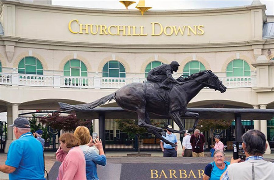 Visitors outside Churchill Downs in Louisville by the racehorse statue